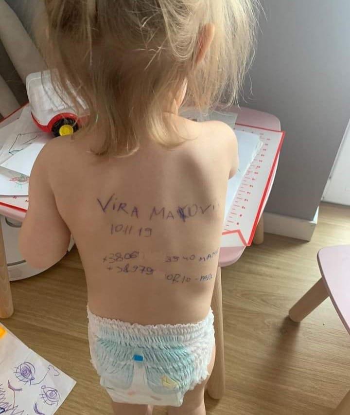 Mãe ucraniana escreve nome e telefone nas costas de filha de 2 anos